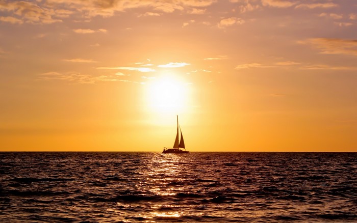 Sailboat on the ocean at sunset