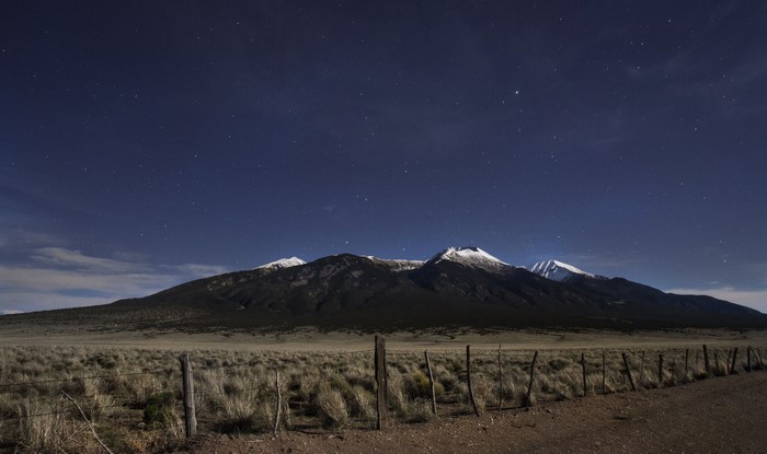 Snow-capped mountains under a starry night sky