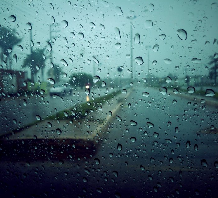 Raindrops on glass overlooking a street