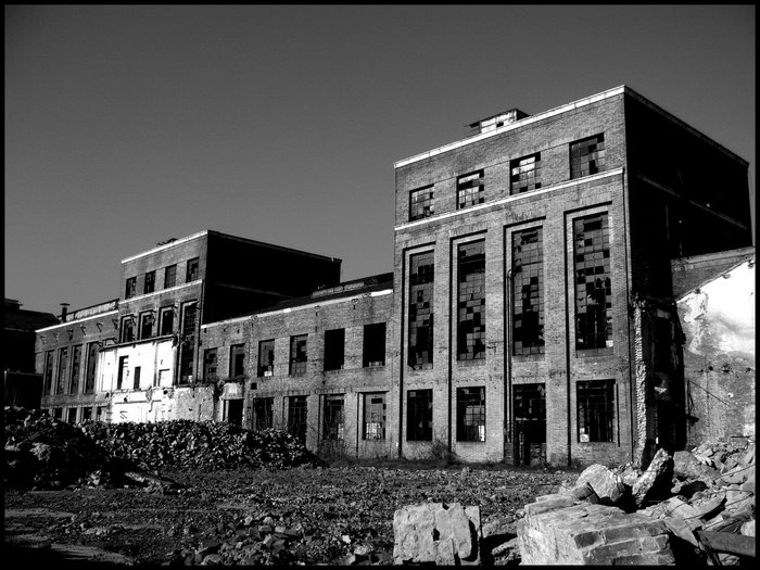 Abandoned brick factory building with broken windows and rubble