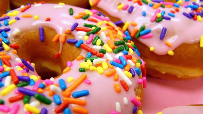 Pink iced donuts with colorful sprinkles