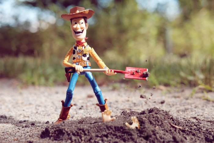 Woody from Toy Story digging with a shovel