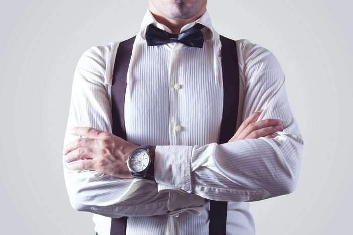 Man in white shirt with suspenders and bow tie