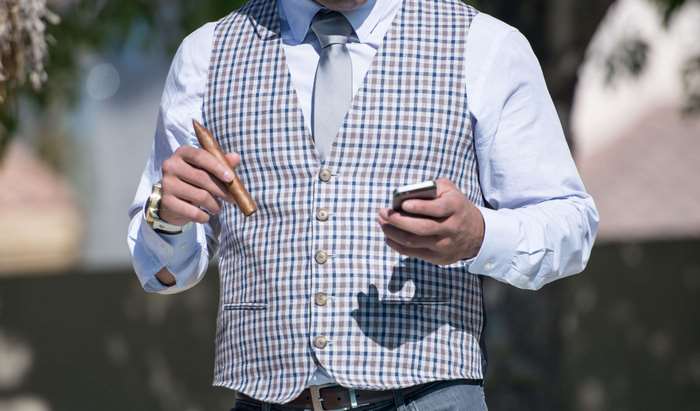 Man in Plaid Vest Holding Cigar and iPhone