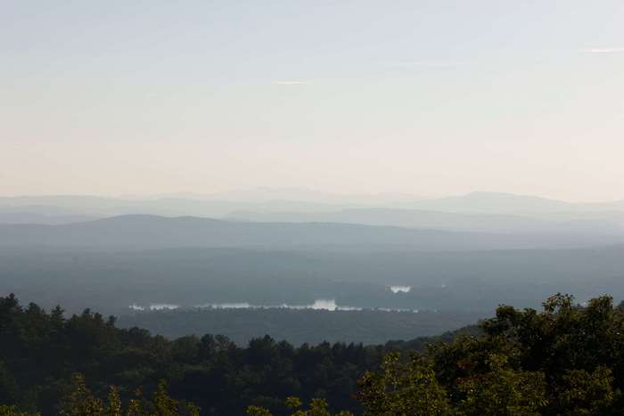 Misty mountain landscape with forest and lake