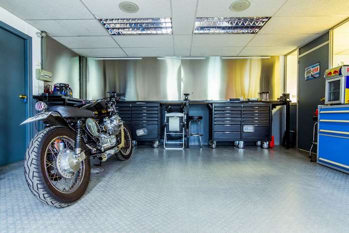 Motorcycle workshop with tool chests and motorcycle