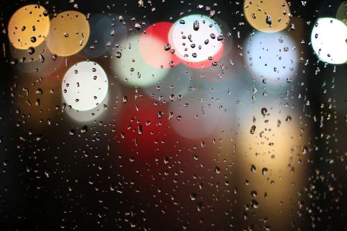 Raindrops on a window with colorful bokeh lights