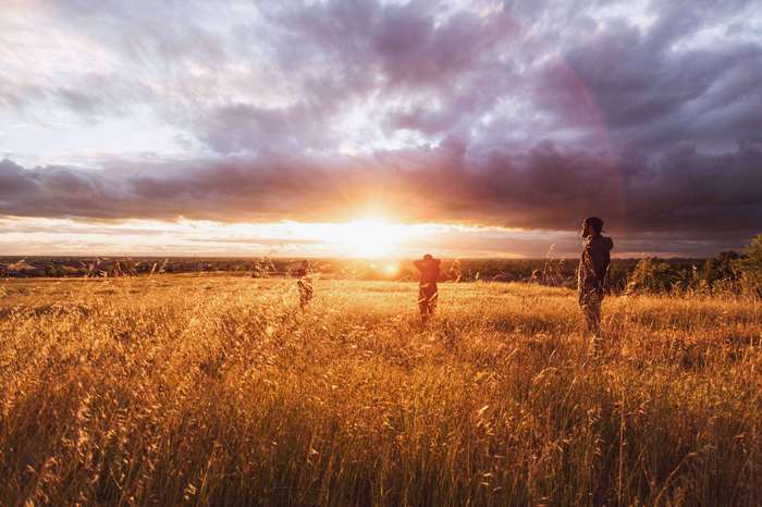 People in a field at sunset 4K