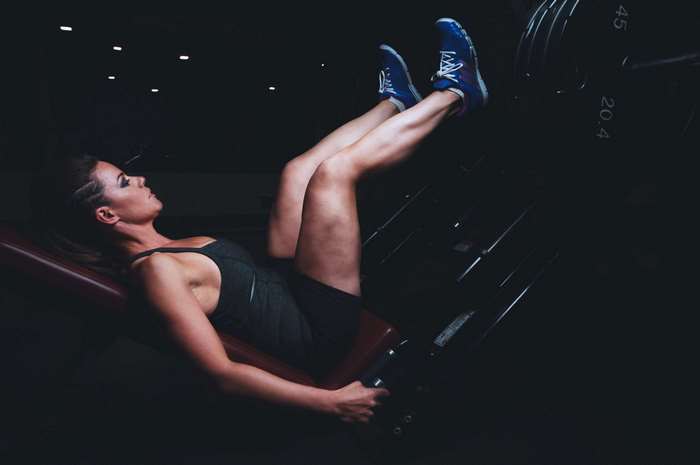 Woman performing leg press exercise in a gym 4K