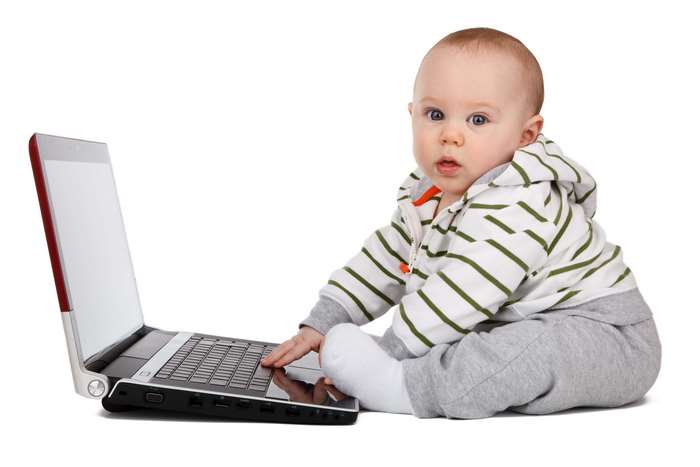 Baby boy sitting with a laptop