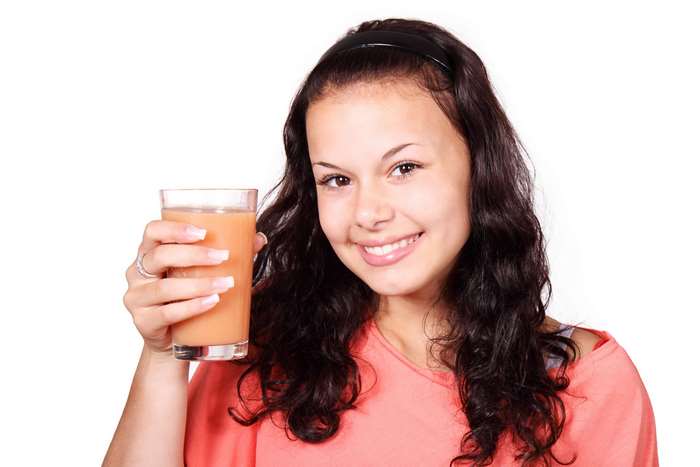 Young woman holding a glass of orange juice