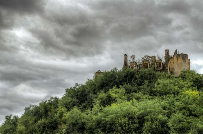 Ruined castle on a hill under stormy skies