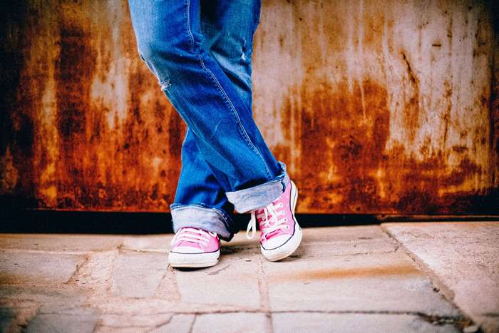 Person wearing blue jeans and pink sneakers