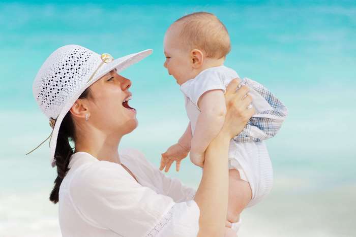 Mother holding baby on beach 4K