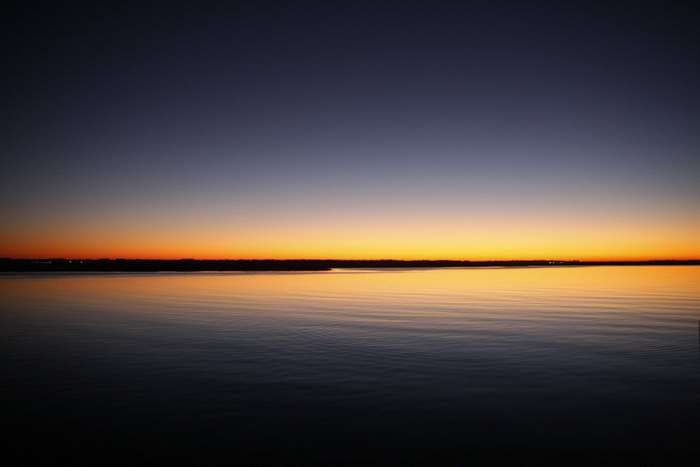 Calm lake at sunset with orange and purple sky