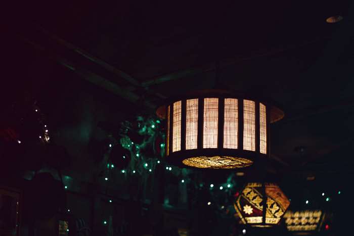 Interior of a dimly lit bar with decorative lanterns and string lights