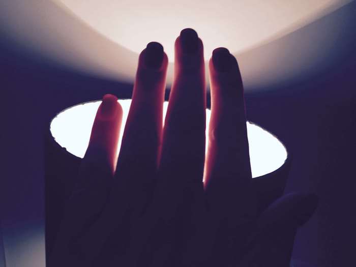 Hand silhouetted against a bright light source