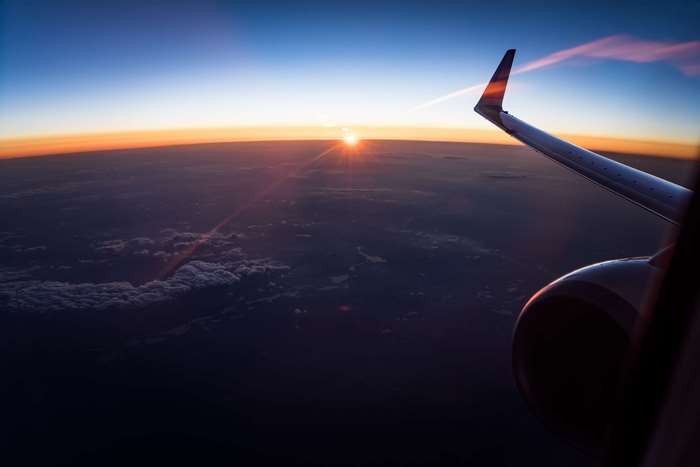 Airplane wing and engine during sunset flight