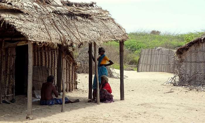 People in a poor village with huts in 4K