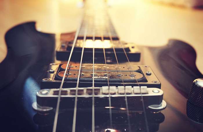 Close up of an electric guitar with strings and pickups
