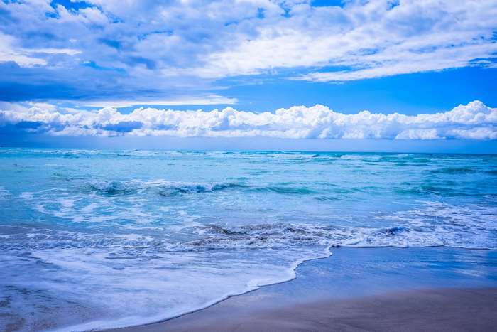 Serene Blue Ocean Waves Under Cloudy Sky