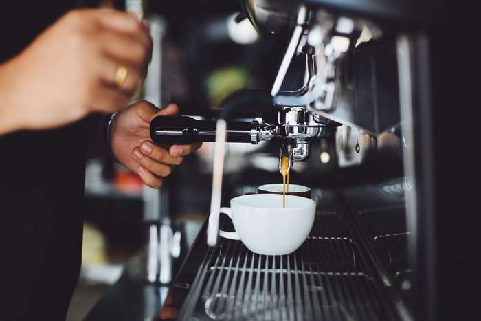 Espresso being brewed in a coffee machine into a cup