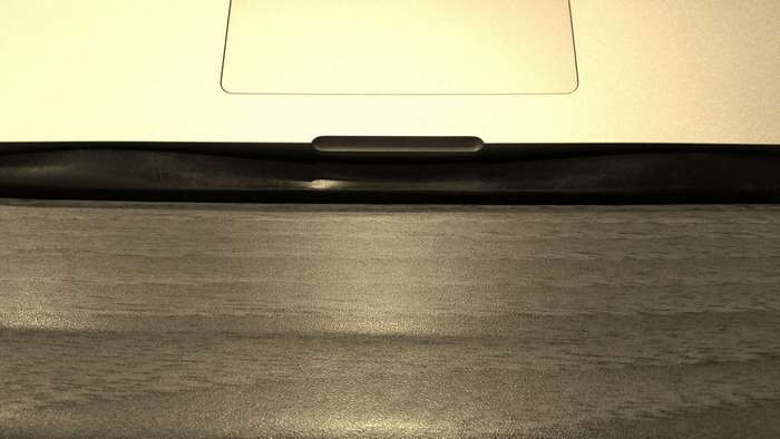 Close-up of a laptop trackpad and wooden surface
