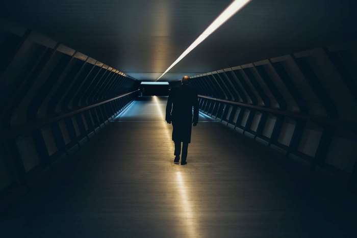 Man walking through a futuristic illuminated tunnel
