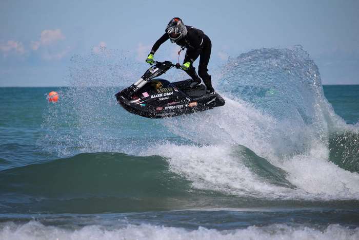 Backie Chan performs a jump on a jet ski in the ocean
