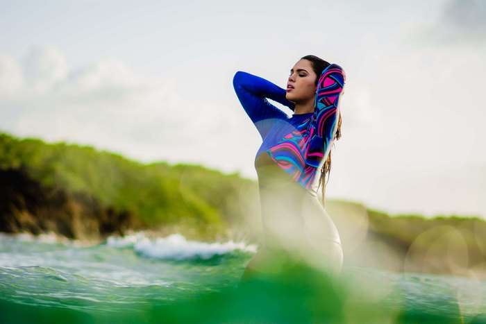 Woman in a colorful rash guard in the ocean