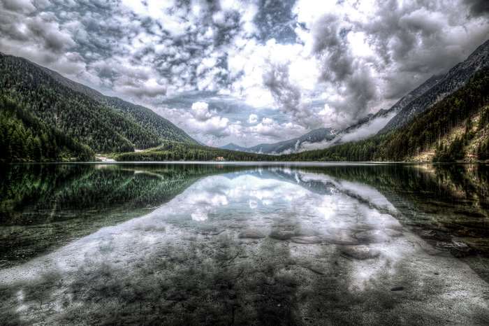 Lake reflecting mountains and cloudy sky