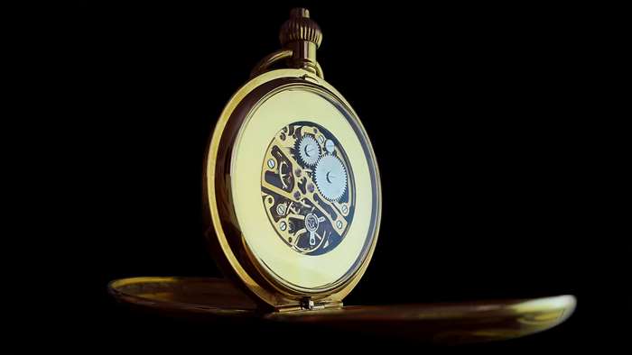Gold pocket watch with visible gears and mechanism