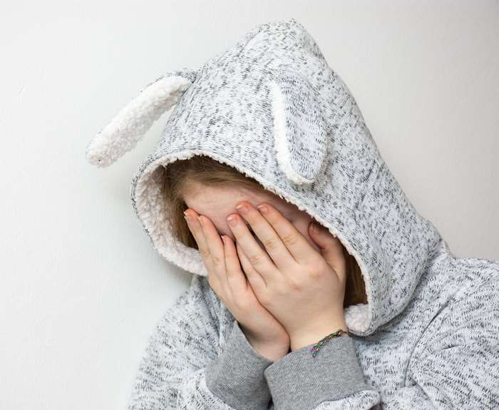 Girl in bunny hoodie covering face