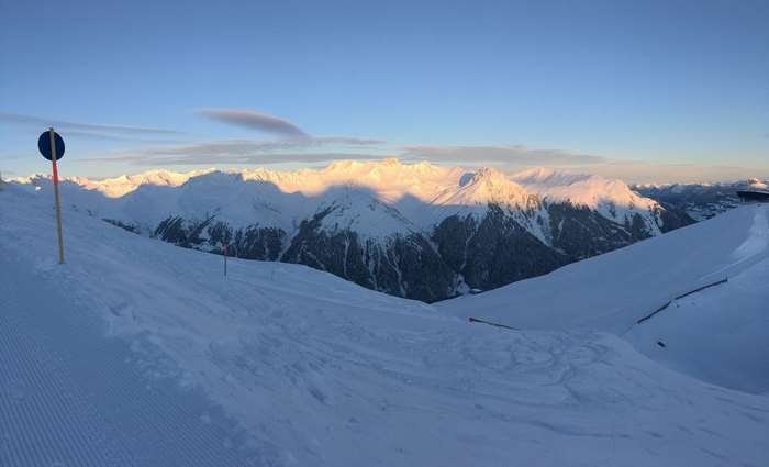 Ski resort with snow-capped mountains at sunrise
