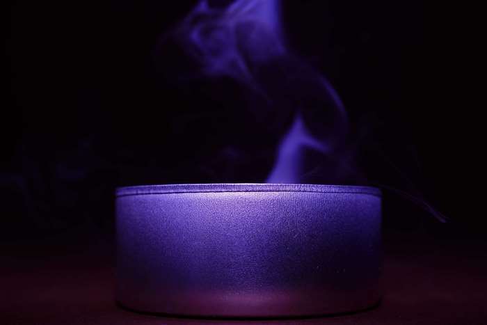 Purple smoke rising from a metallic container