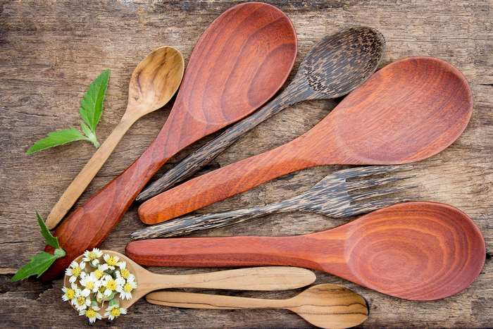 Wooden kitchen utensils and flowers on a rustic table