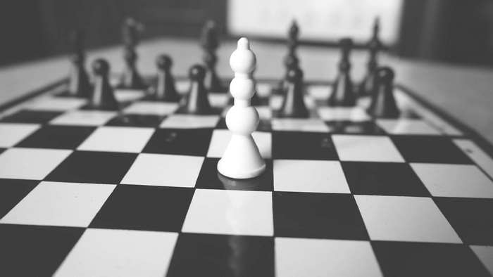 Black and white chessboard with white queen and pawns