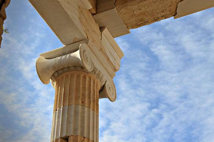 Ancient Greek Ionic column and entablature against blue sky