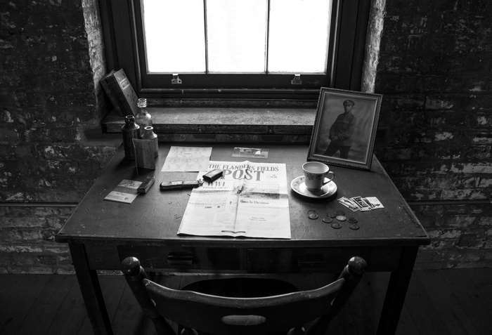 Desk with newspaper, photo, and cup in black and white