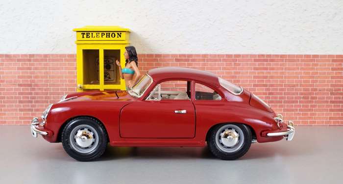 Red Porsche 356 model with a woman and phone booth