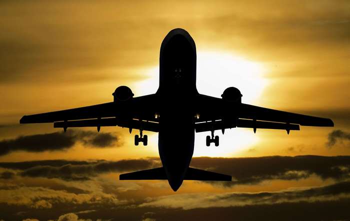 Silhouette of an airplane taking off at sunset