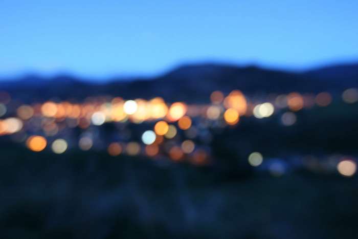 Blurred city lights at night with mountains