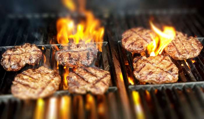 Burgers grilling over open flames on a barbecue