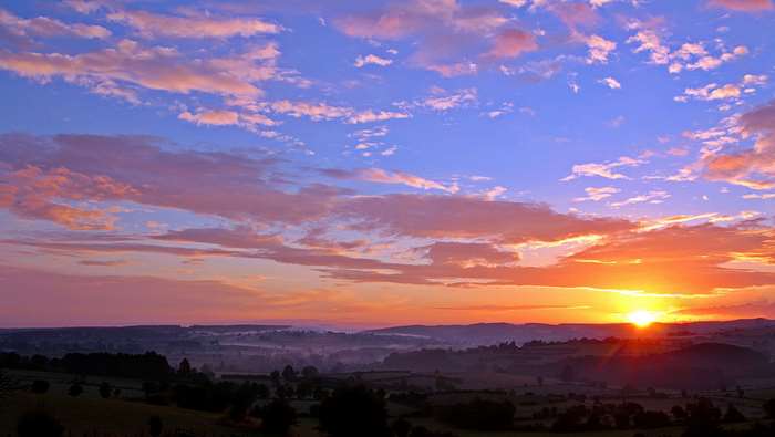 Sunset Over Rolling Hills with Colorful Sky