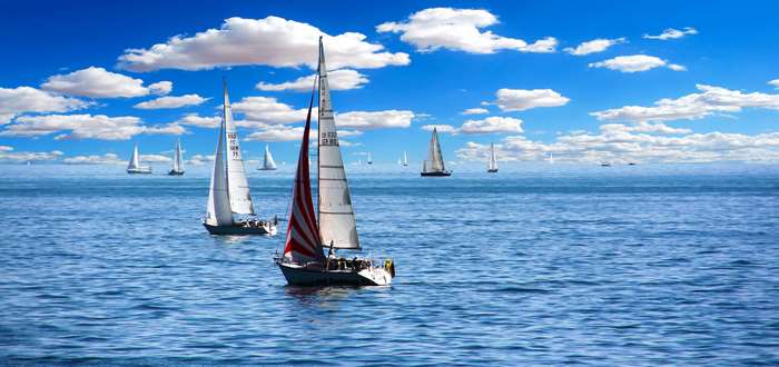 Sailboats on the ocean under a cloudy blue sky 4K
