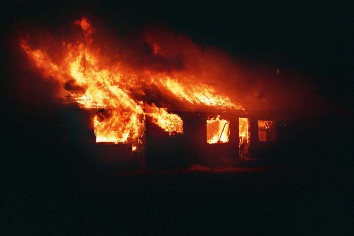 A house engulfed in flames at night