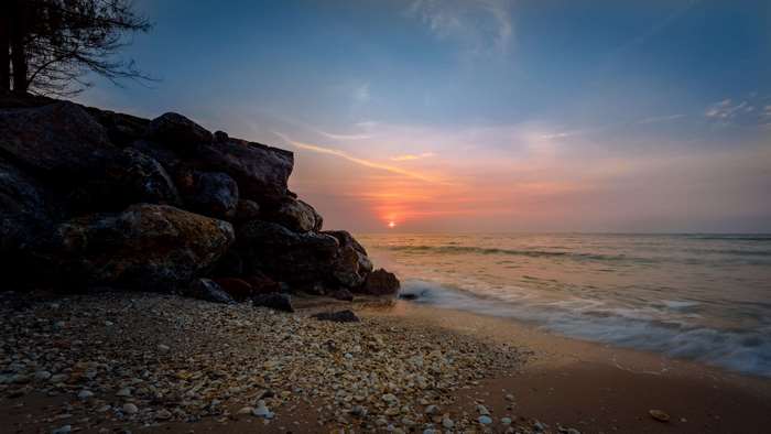 Beach with rocks and ocean at sunset
