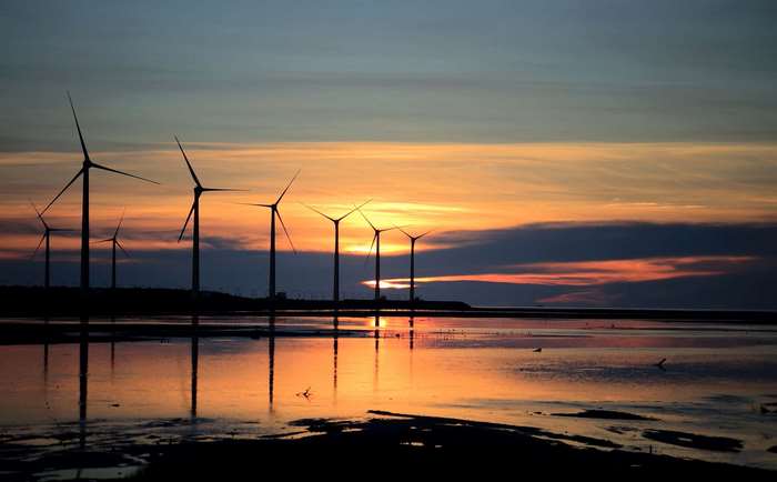 Wind turbines at sunset over water