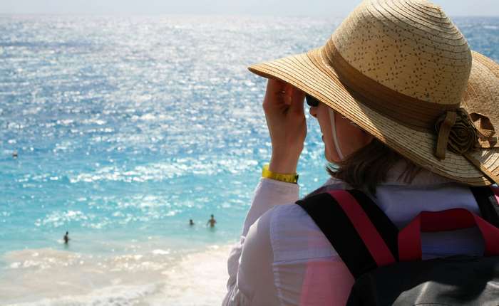 Woman in sun hat looking at the ocean