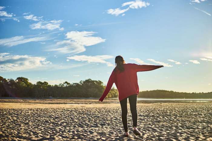 Woman in red sweater on a sandy beach
